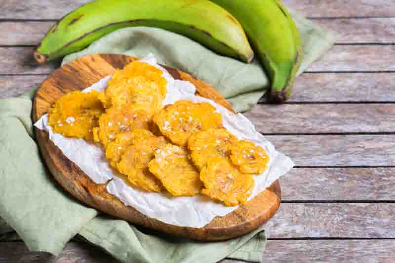 Traditional Central American caribbean cuban colombian food. Fried tostones, green bananas plantains with guacamole sauce. Top view, flat lay