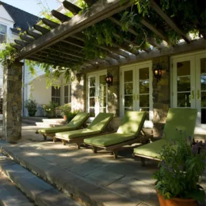 Garden ideas, Landscaping Ideas, arbor, pergola, french doors,green,lanterns,lounge chairs,pergola,posts,potted plants,seat cushions,shady, steps,stone facade, stone floor, stone walls,vines,walls sconce,white painted trim,wisteria