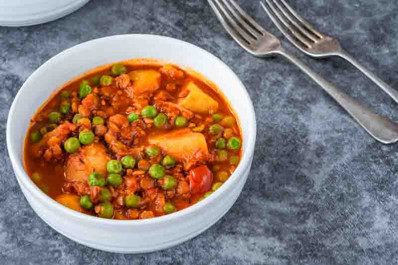 Vegetarian potato and pea curry with brown lentils and tomatoes