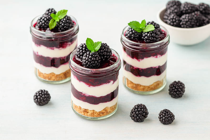Cheesecake topped with glossy blackberry compote and fresh berries