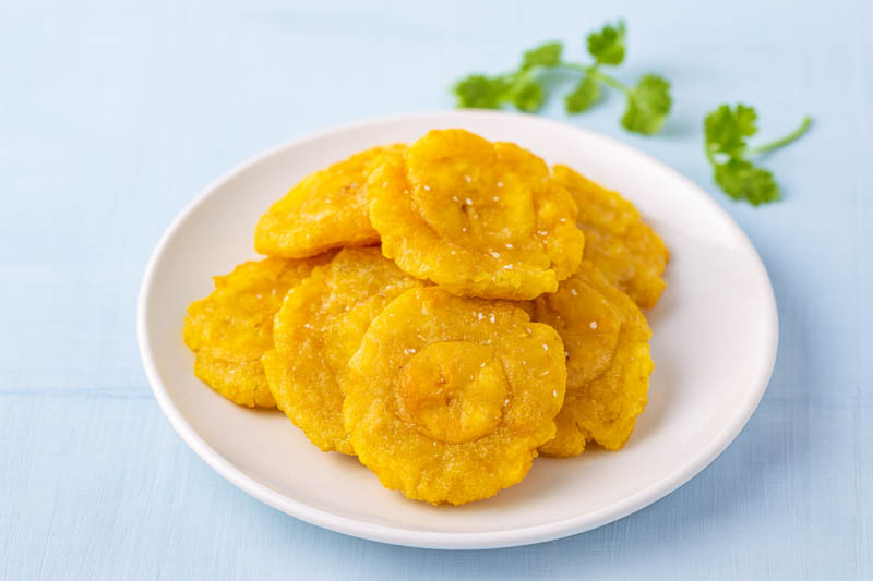 Tostone in a plate, Fried green plantains (tostones) with dipping sauces Plantain, Cooking banana, Edible banana, Banana, Musa x paradisiaca