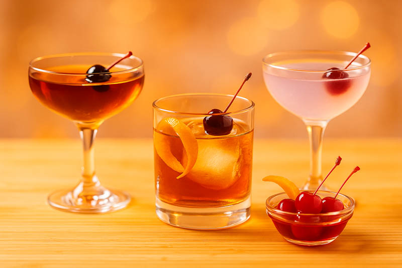 Maraschino cherries on a cocktail pick in a classic drink