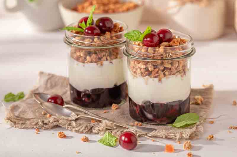 Yogurt bowl topped with fresh cherries and sliced almonds