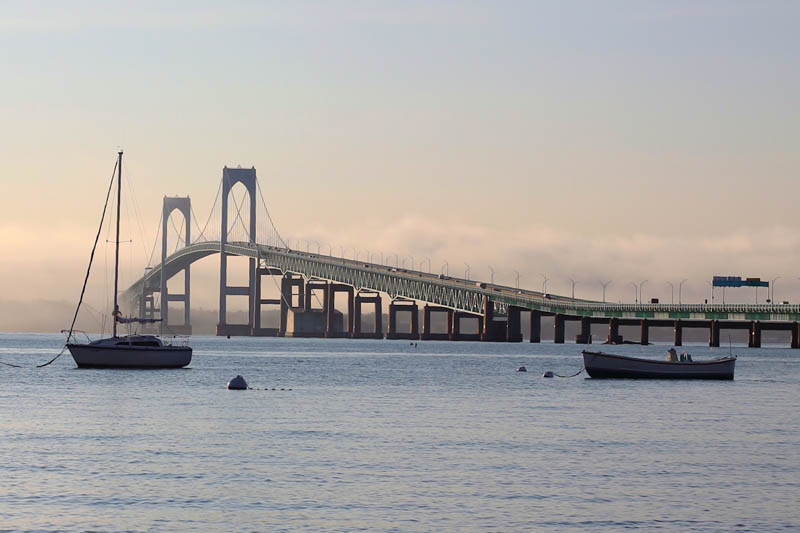 Newport Bridge in the background with two boats. Just before sunset.
