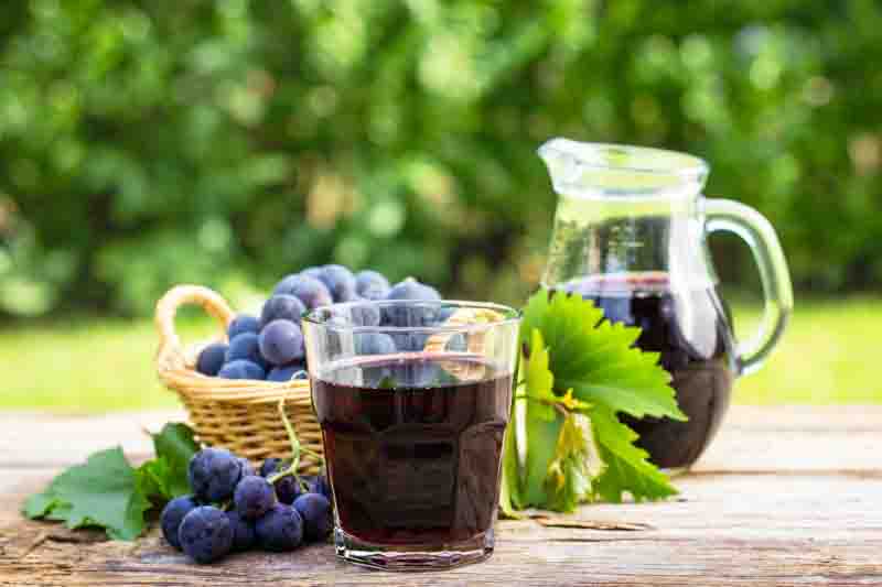 Refreshing grape juice on rustic table